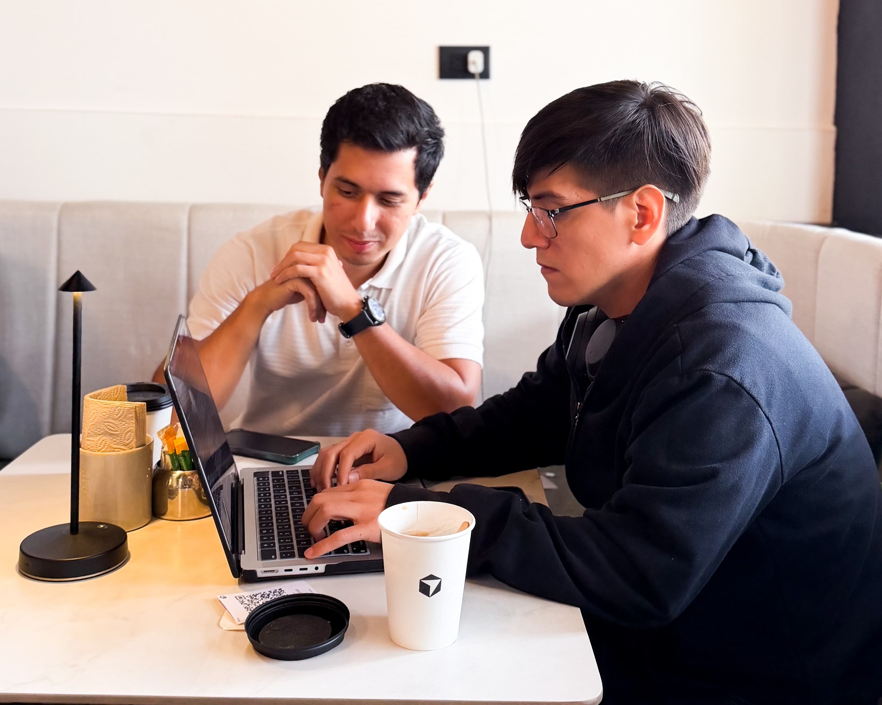 Dos builders colaborando frente a una laptop en Guayaquil